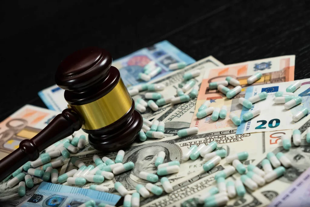 A pile of pills and money with a gavel on it.