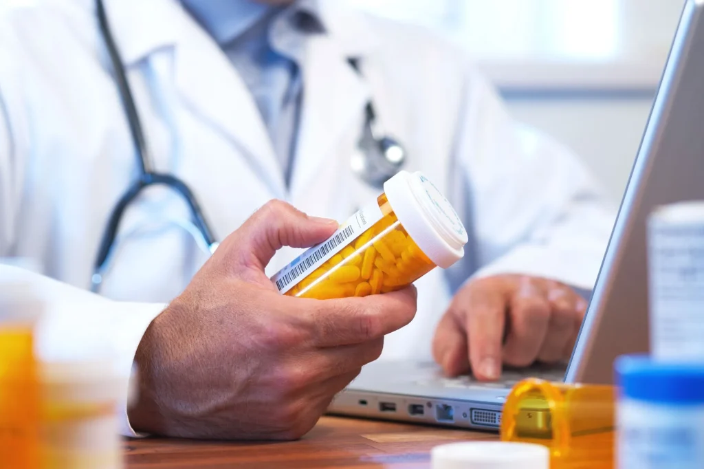 Doctor looking at bottle of prescription pills. Pharmaceutical liability attorney Baltimore Maryland