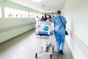 Doctor wheeling stretcher down hallway 