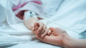 A mother having her hand held after sustaining a medical complication after an untimely C-section. If you or your baby has sustained a birth injury our medical malpractice lawyers in Baltimore can help.