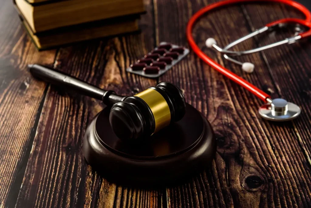 Gavel and stethoscope sitting next to a pack of pills on a desk. Our medical malpractice lawyers in Baltimore Maryland have experience working with many types of medical malpractice and surgical error cases.