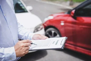 An adjuster looking over damages after a car accident. Our experienced personal injury lawyer in Baltimore, MD can assist you with the legal process after filing a lawsuit after an auto accident.