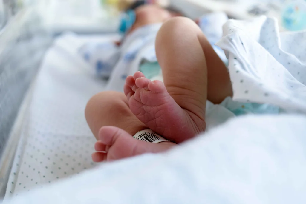 A newborn baby in a hospital blanket.