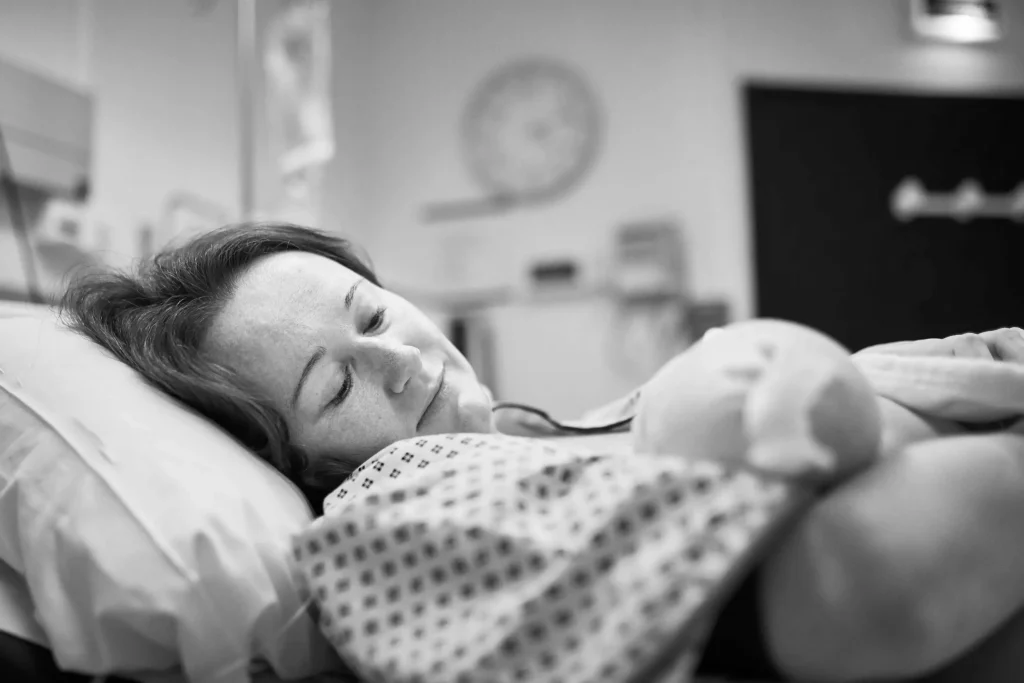 A mom holding her newborn baby in the hospital.